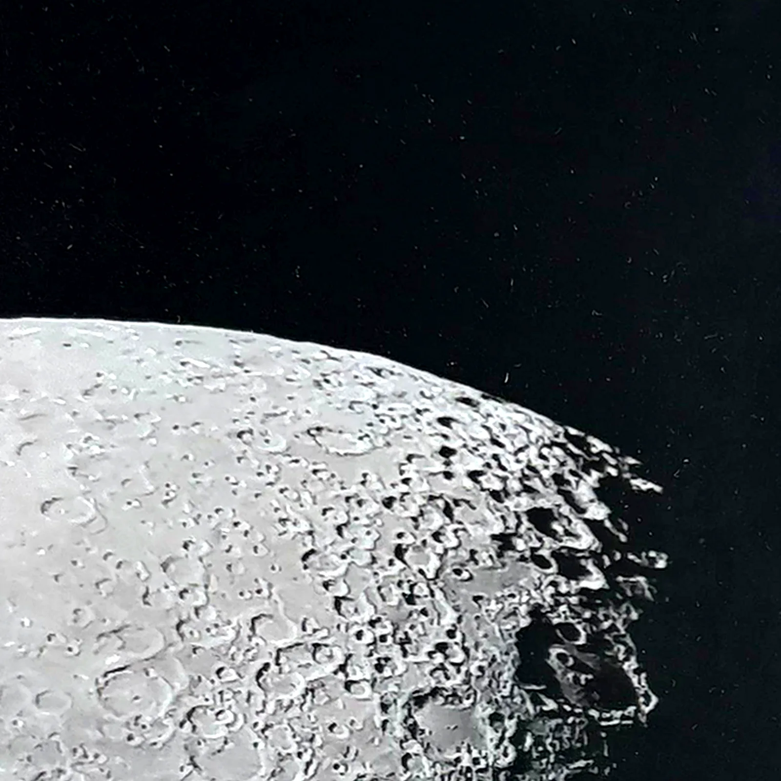 Photo surface lunaire avec météorite NWA XXX – cadre noir – gros plan sur la météorite