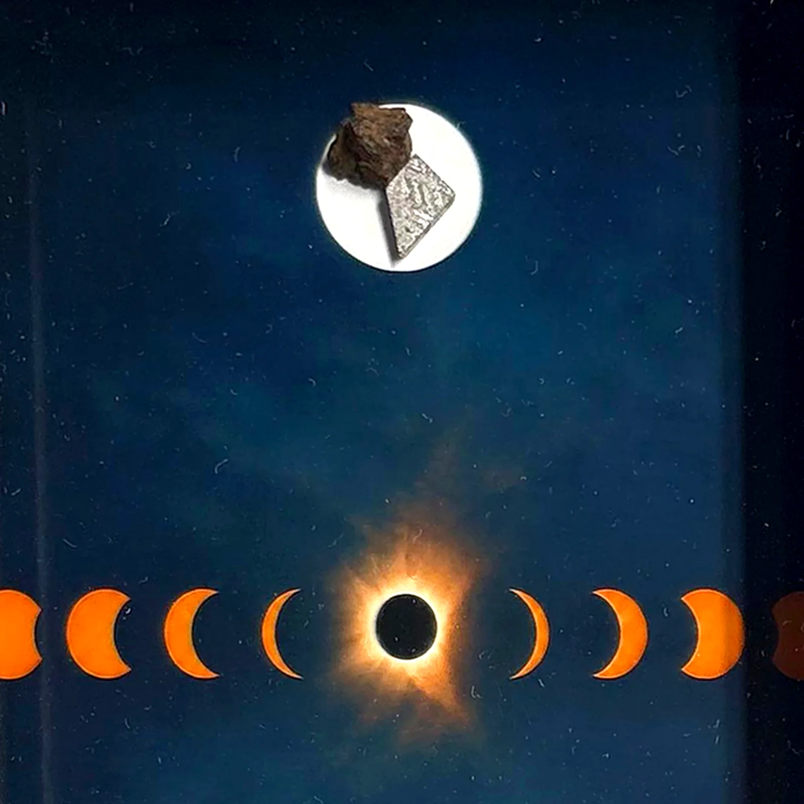 Tableau éclipse solaire avec météorites Aletai et NWA 14093 – cadre profondeur – gros plan sur la météorite