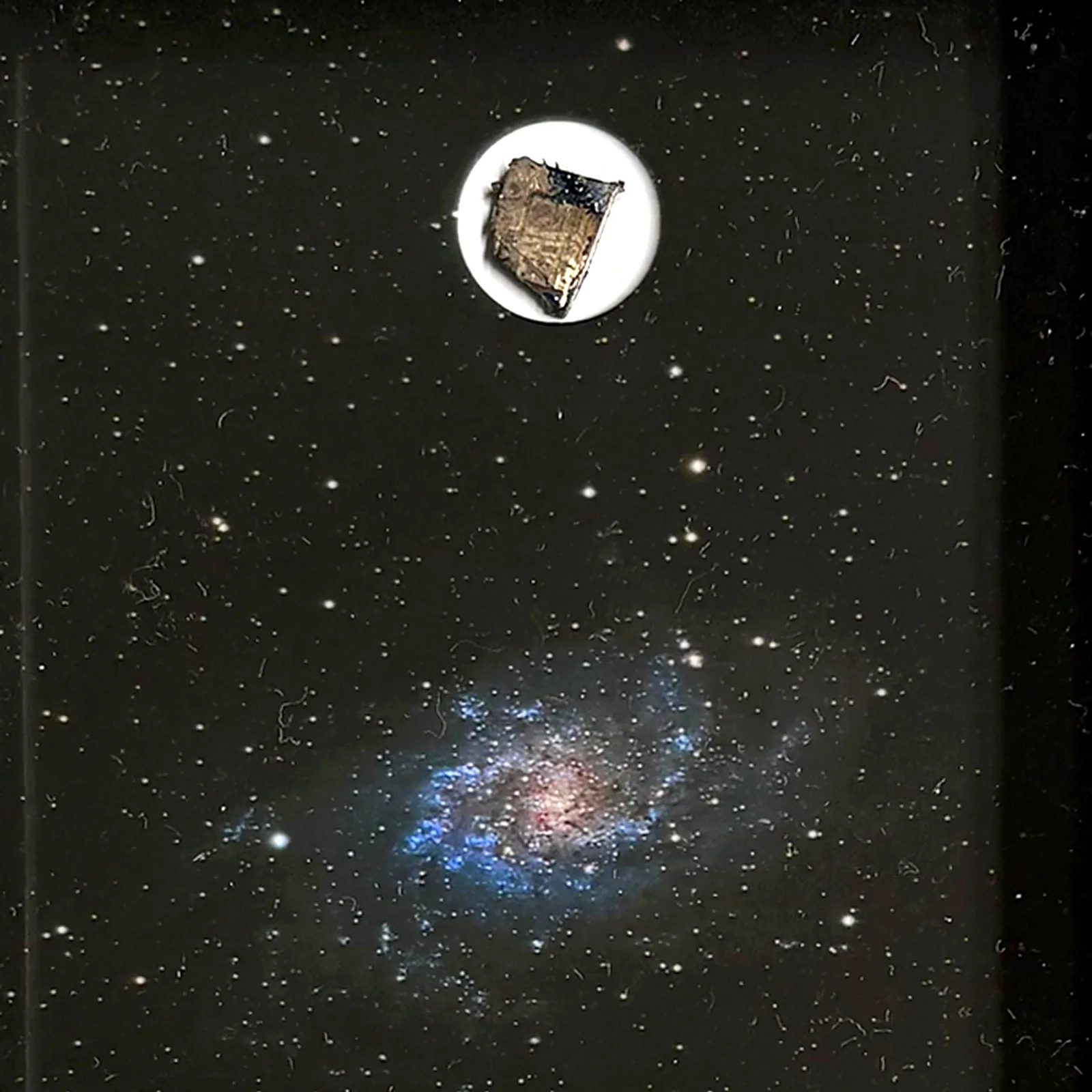 Tableau galaxie du Triangle avec météorite Muonionalusta – cadre profondeur – gros plan sur la météorite